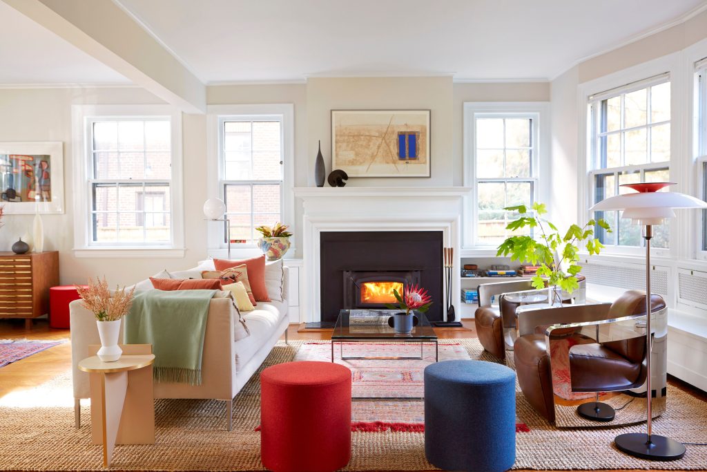 Living room with a fireplace and colorful ottomans