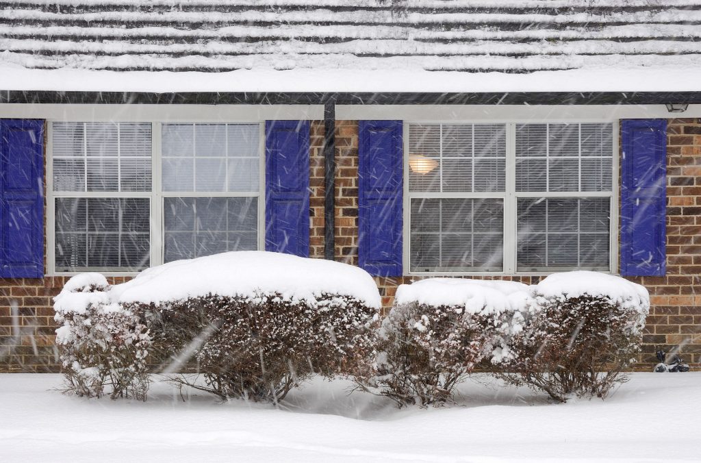 exterior windows of home with blue shutters and snow outside