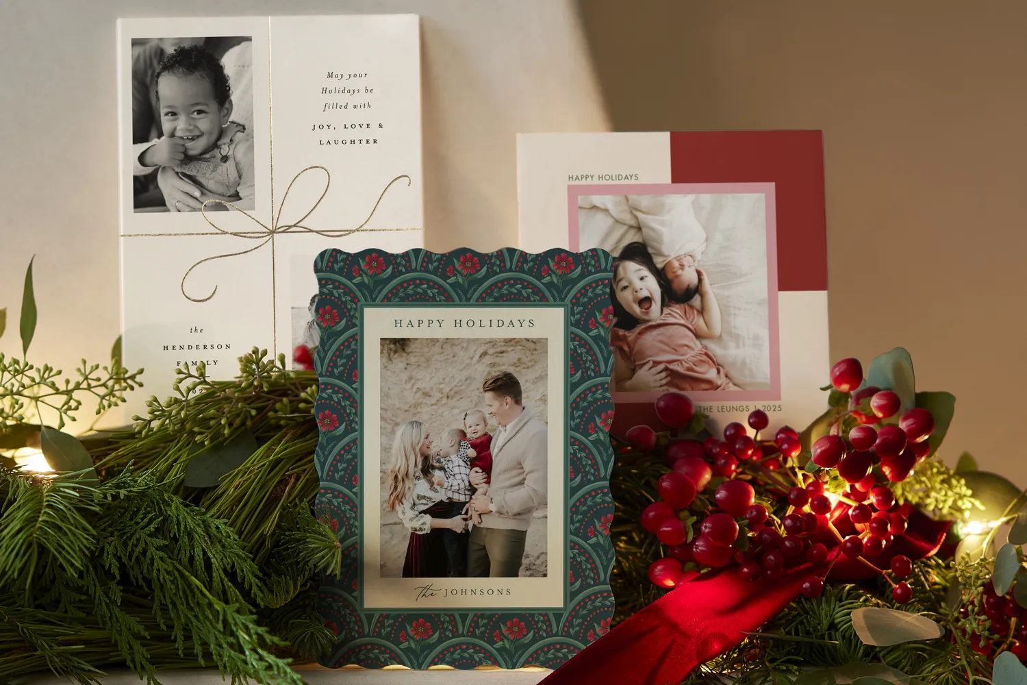 Holiday cards on a decorated mantle with greenery and berries