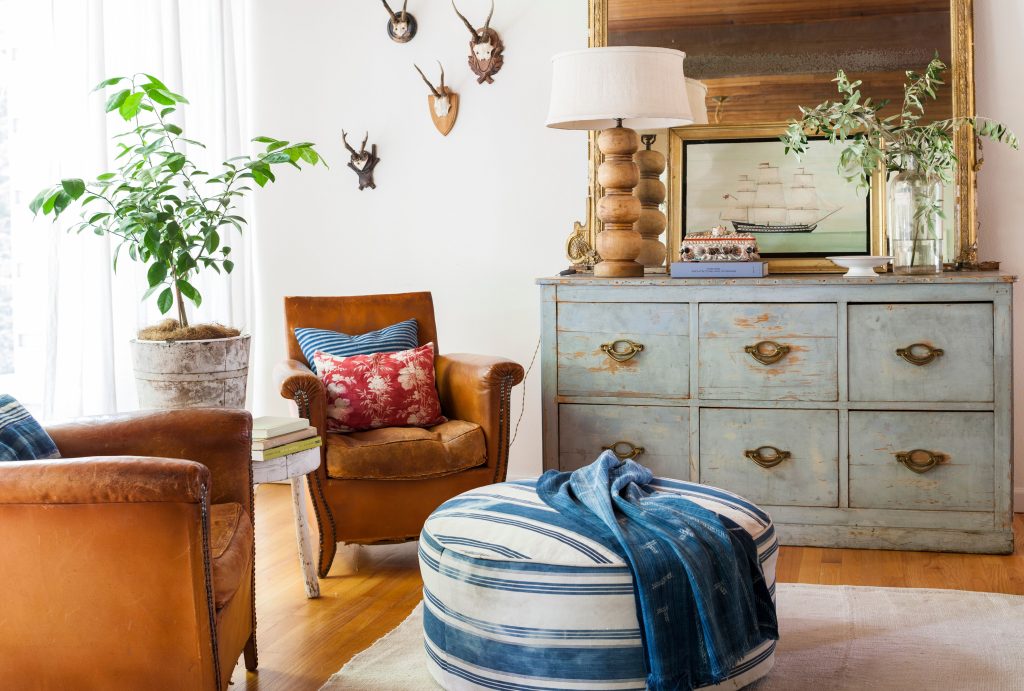 Country home decorating with distressed dresser and leather chairs