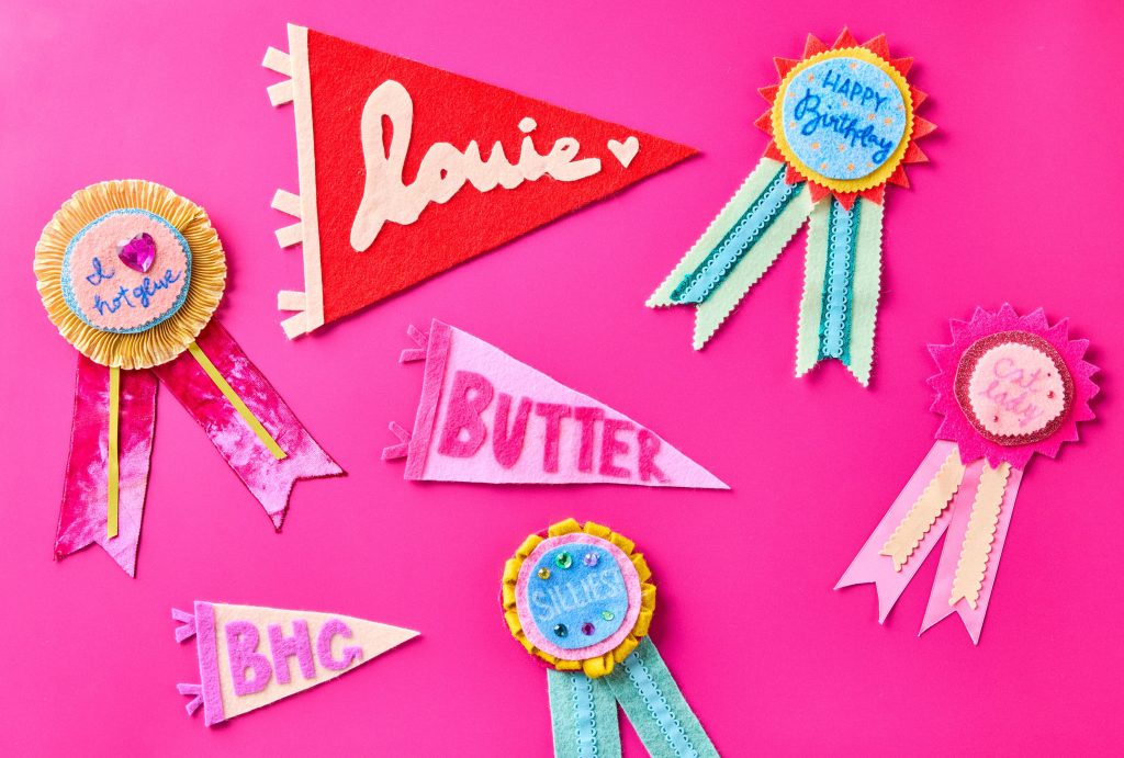 Collection of handmade felt badges and pennants with text and decorative elements