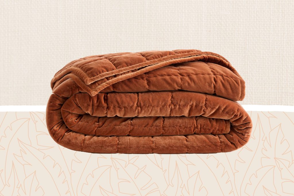 Folded velvet quilt displayed on a patterned surface