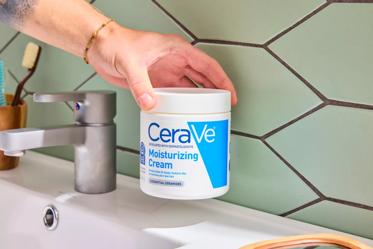 A person holding up the CeraVe Moisturizing Cream