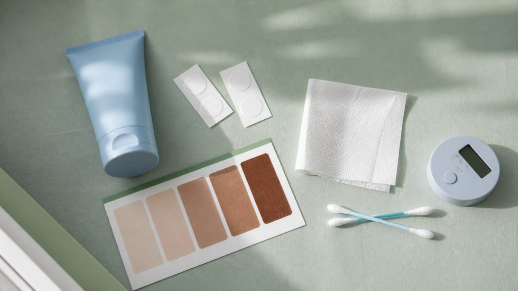 Skincare supplies arranged in sage green tabletop for skin type test for tanning