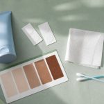 Skincare supplies arranged in sage green tabletop for skin type test for tanning