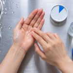 Applying lotion to palm in stainless steel sink area for korean skincare second rule