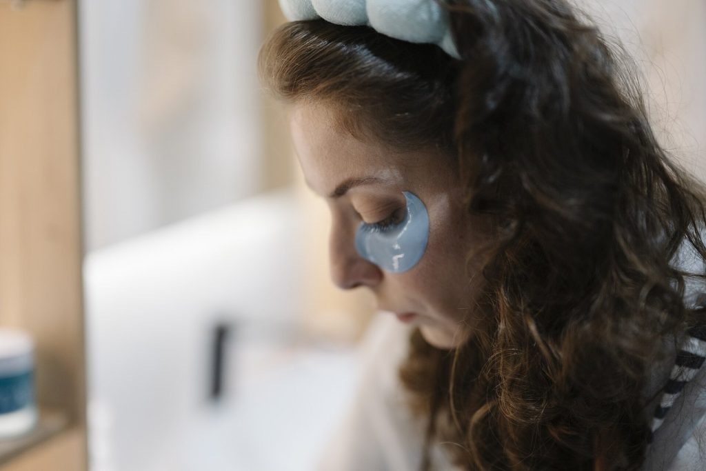 Woman wearing a padded fabric headband and a blue crescent-shaped under-eye patch